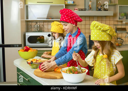 Children making salad, kitchen. Stock Photo