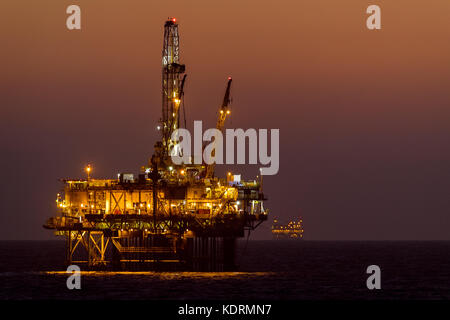 Oil Rigs/Platforms operating off the Huntington Beach, California coast at dusk in the Fall. Stock Photo