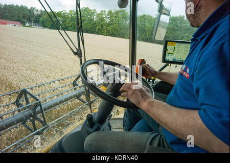Combine harvester cutting wheat in a small field near Perth in Scotland Stock Photo