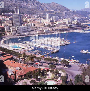 1960s, historical, aerial view of Port Hercules with boats and yachts moored up at Monte Carlo, France. In the foreground the roads used for the Monaco Grand Prix which goes around the port. Stock Photo