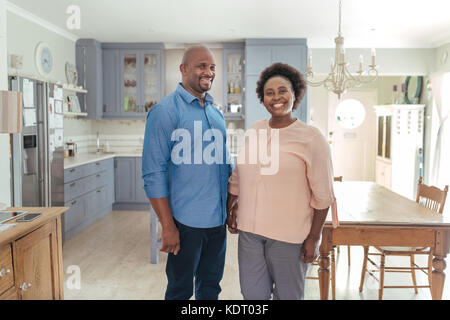 Smiling mature African couple standing together in their kitchen Stock Photo