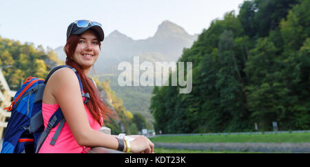 Image of tourist girl with backpack backdrop of mountains Stock Photo