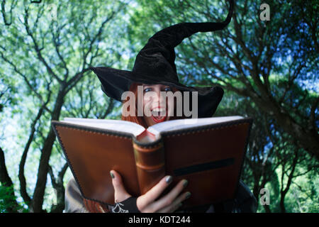 Photo of screaming witch in long black hat Stock Photo