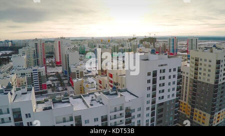 Aerial view on residential area. A newly completed housing estate in a summer setting. Aerial new estate with neighborhood faculties car park and green garden at the center. Stock Photo