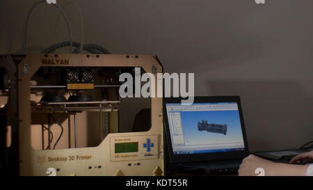 Working With 3D Printer In Design Studio. Designer Working With 3D Printer Stock Photo