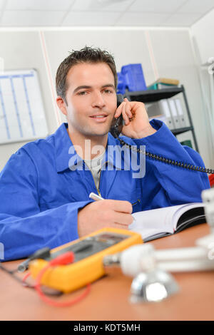Man in overalls on telephone Stock Photo