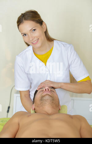 man receiving head massage in medical office Stock Photo