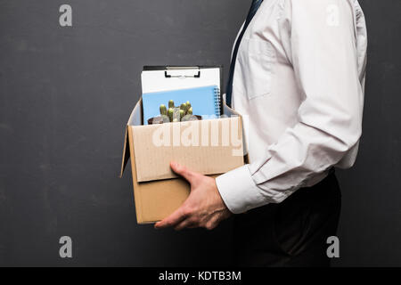 Young handsome businessman in light modern office with carton box. Upset office worker is fired. Stock Photo