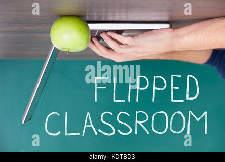 Flipped Classroom Concept On Blackboard With Person Using Laptop Stock Photo