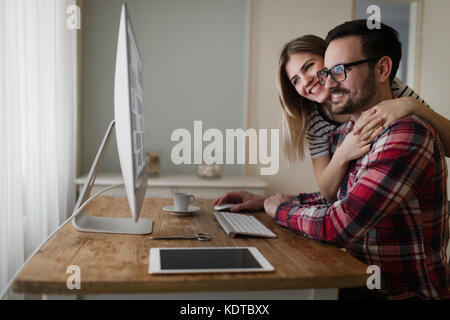 Beautiful woman and attractive man doing design work Stock Photo