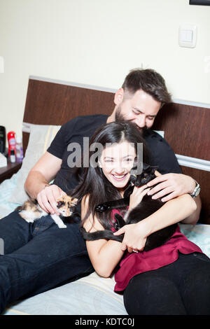 Couple relaxing on the bed with their cats Stock Photo