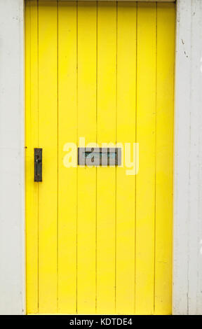 Yellow painted wooden door with letter box