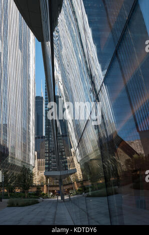 Sunlit Chicago downtown skyscraper reflected in the glass wall of the adjacent structure. Stock Photo