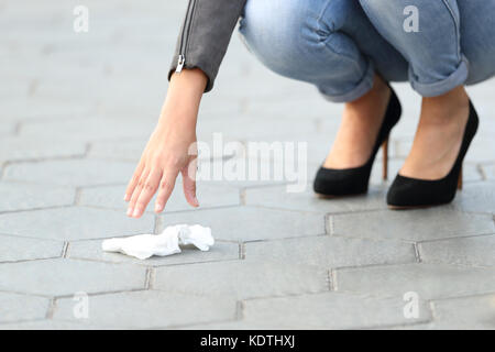 Close up of a woman hand picking garbage of the sidewalk on the street Stock Photo
