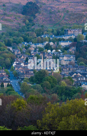 Evening view over residential buildings & high street, nestling in Wharfe Valley under moorland - Ilkley town centre, West Yorkshire, England, UK. Stock Photo