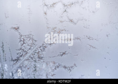 Fancy intricate winding diagonal frosty pattern on window glass in winter. Stock Photo