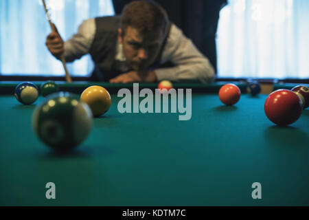 Young caucasian man playing billiards ready to shoot. Stock Photo