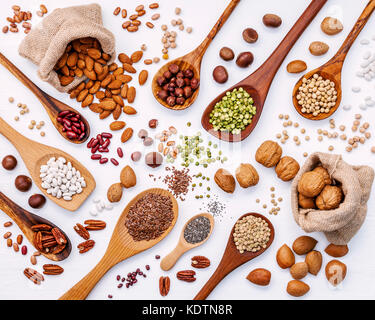 Various legumes and different kinds of nuts in spoons. Walnuts kernels ,hazelnuts, almond ,brown pinto ,soy beans ,flax seeds ,chia ,red kidney beans  Stock Photo
