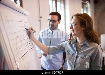 Portrait of architects discussing and drawing on board Stock Photo