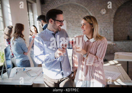 Happy young architects having break and drinking wine Stock Photo