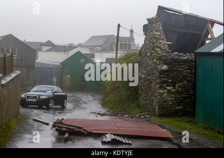 Schull, Ireland. 16th Oct, 2017. UK Weather.  Ex-Hurricane Ophelia hits Schull, Ireland with winds of 80kmh and gusts of 130kmh.  Major structural damage is expected as the worst is yet to come. A tin roof blocks the entrance and exit to Centra in Schull. Credit: Andy Gibson/Alamy Live News. Stock Photo
