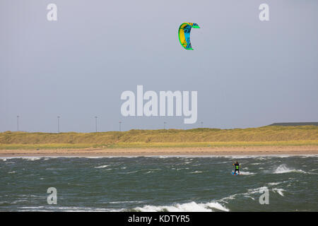 Anglesey, Wales. 16th Oct, 2017. UK Weather.  As forecasted with Yellow and Amber and the more dangerous Red warnings by the Met Office Hurricane Ophelia will begins to make landfall to most western parts of the UK including Wales bring storm weather and sea surges as this kite boarder was making use of at rhosneigr on Anglesey ,Wales.