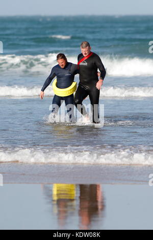 Newquay, UK. 16th Oct, 2017. UK Weather. Strong offshore winds from ex-Hurricane Ophelia blow back the high surf on the north coast of Cornwall on Fistral Beach. Lifeguards practice rescues in the rough seas. Credit: Nicholas Burningham/Alamy Live News Stock Photo