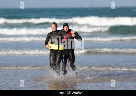 Newquay, UK. 16th Oct, 2017. UK Weather. Strong offshore winds from ex-Hurricane Ophelia blow back the high surf on the north coast of Cornwall on Fistral Beach. Lifeguards practice rescues in the rough seas. Credit: Nicholas Burningham/Alamy Live News Stock Photo