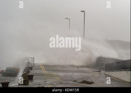 Schull, Ireland 16th Oct, 2017.  Ex-Hurricane Ophelia hits Schull, Ireland with winds of 80kmh and gusts of 130kmh. Waves crash over the Schull pier wall at the height of the hurricane. Credit: Andy Gibson/Alamy Live News. Stock Photo