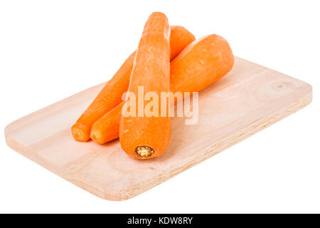 three carrots on wood cutting board isolated on whited Stock Photo