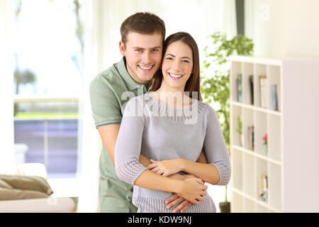 Portrait of a proud homeowners posing looking at you standing in the living room at home Stock Photo