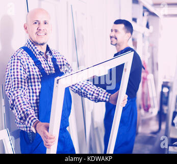 Two positive workmen inspecting PVC manufacturing output in workshop Stock Photo
