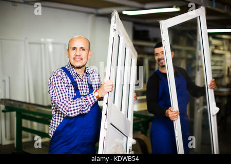 Two positive workers inspecting PVC manufacturing output in workshop Stock Photo