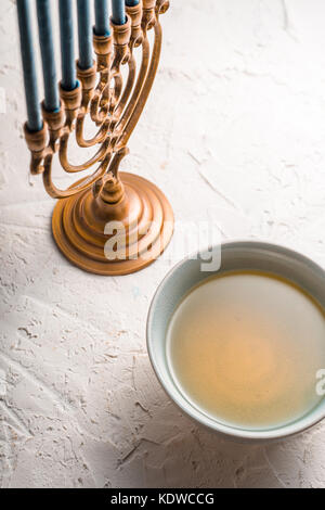 Chanukiah fragment and bowl with olive oil side view vertical Stock Photo