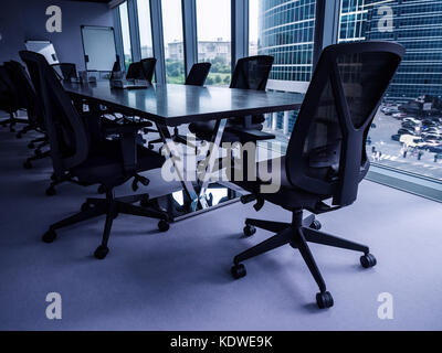 Empty conference room overlooking downtown district, shallow depth of field, blue toned Stock Photo