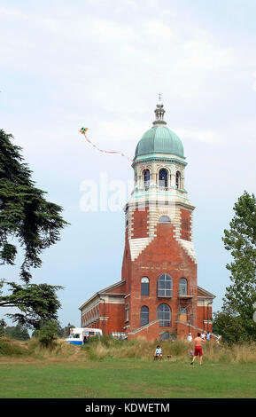 Child flying a kite in front of the Netley Chapel at the Royal Victoria Country Park on Southampton Water Hampshire England UK Stock Photo