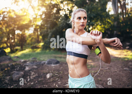 Woman warming up before a run. Runner doing stretching exercises. Stock Photo