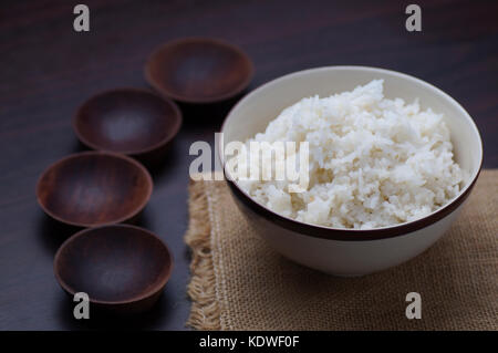 Thai rice in bowl with wooden empty and small bowl  on table  in dark tone Stock Photo