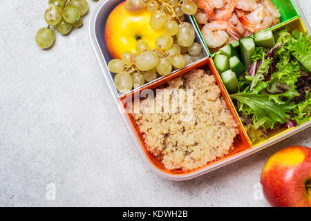 lunch box with a balanced meal. Fruits Vegetables Proteins and Carbohydrates in multi-colored box. Healthy food concept in the office. Stock Photo
