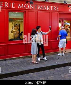 A young tourist couple take a selfie or shoot video using their gopro camera in Montmartre, Paris Stock Photo