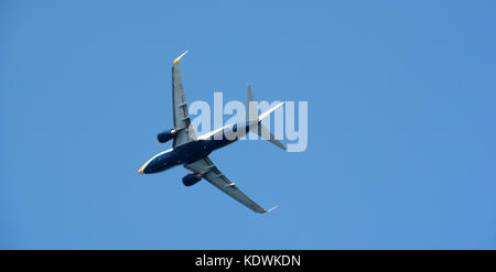 Underside of a twin engine jet taking off against a blue sky Stock Photo