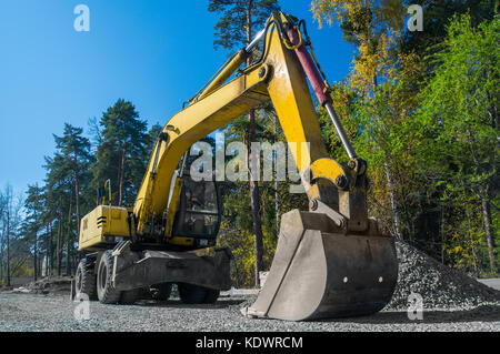 Road repair, asphalt laying. Yellow wheeled excavator Stock Photo