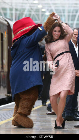 The Duchess of Cambridge dances with a costumed figure of Paddington bear on platform 1 at Paddington Station, London, as she attends the Charities Forum event, joining children from the charities she supports and to meet the cast and crew from the forthcoming film Paddington 2. Stock Photo