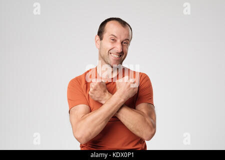 Happy mature man crossing his arms in front of the chest, showing his power and strength. Stock Photo