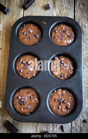 Basic homemade brownie or chocolate muffins raw dough in baking pan. Cooking (baking) homemade chocolate muffins, cupcakes or brownies. Stock Photo