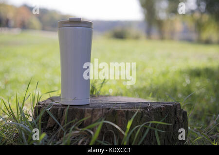 thermo mug stands on a stump Stock Photo