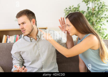 Angry couple arguing sitting on a sofa at home Stock Photo