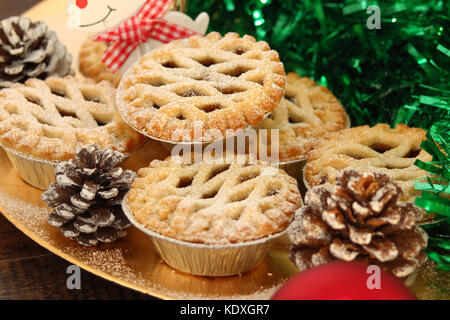 Christmas mince pies on a gold plate with white reindeer on a wood background Stock Photo