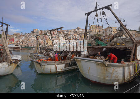 A fisherman cleaning his boats during a month's fishing embargo in the port of Sciacca. From a series of travel photos in Sicily, Italy. Photo date: T Stock Photo