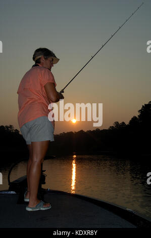 A woman fishes for crappie from her boat on Lake Sam Rayburn near Jasper Texas Stock Photo